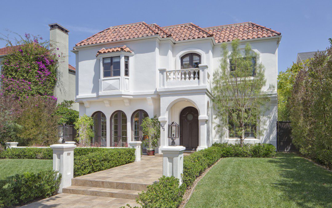 A luxurious white house in Los Angeles with a sprawling front yard.
