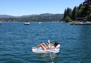 A woman floating on an inflatable raft in a lake.