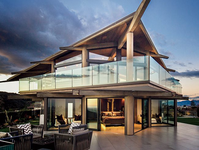 A modern home with a large deck and a view of the ocean.