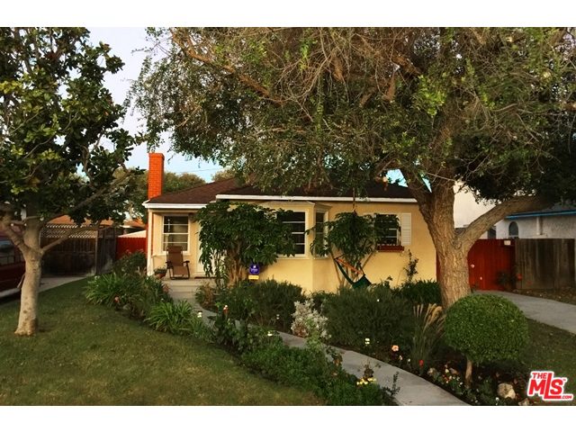 A house with trees and bushes in front of it.