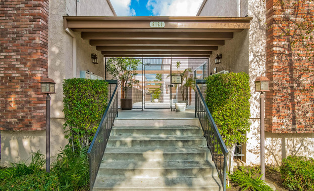 The entrance to an apartment building with stairs leading up to it.