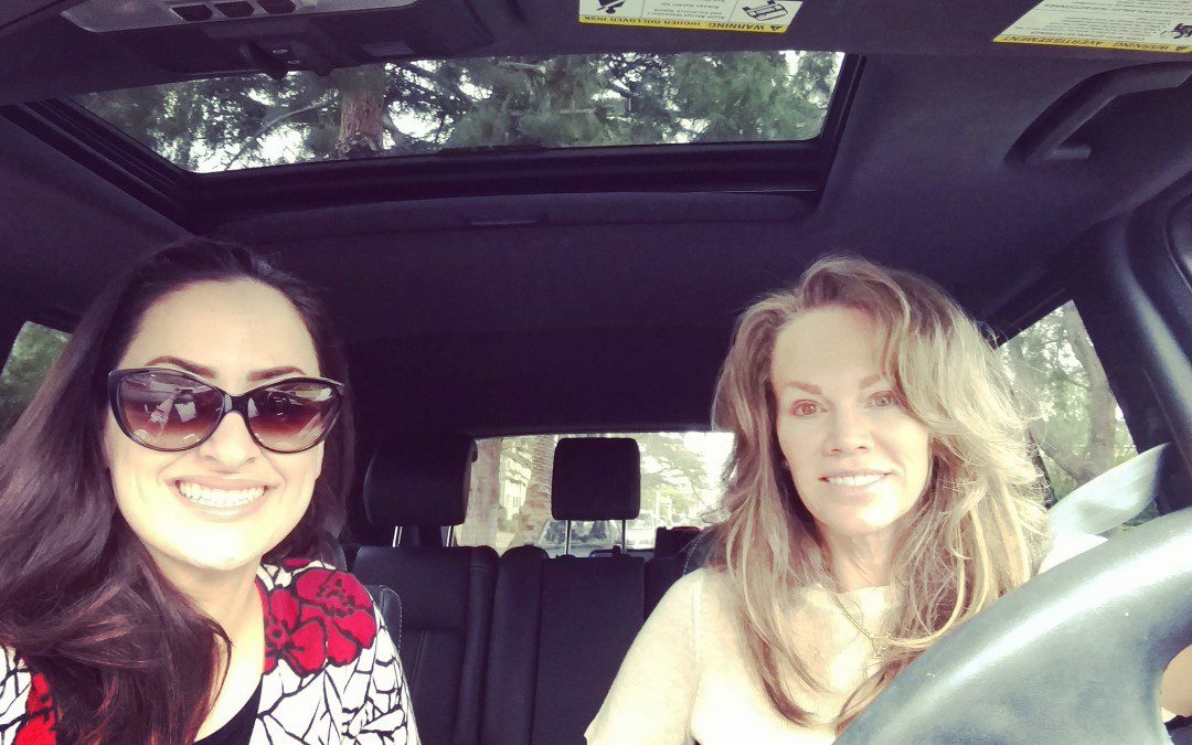 Two women sitting in the driver's seat of a car.