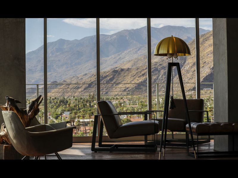 A living room with chairs and a view of mountains.