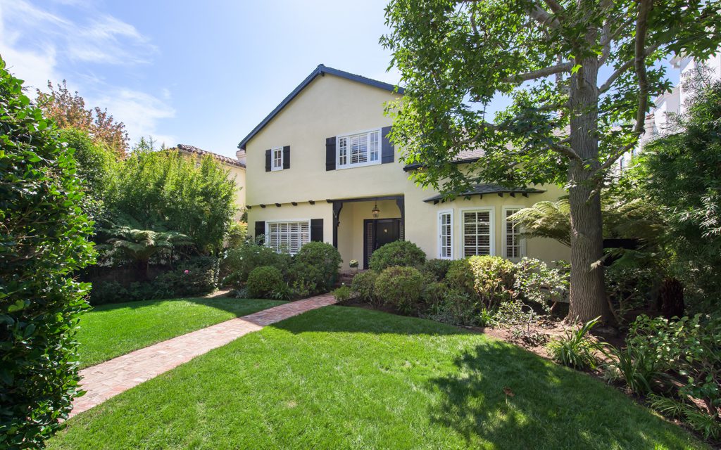 A home with a green lawn and bushes.